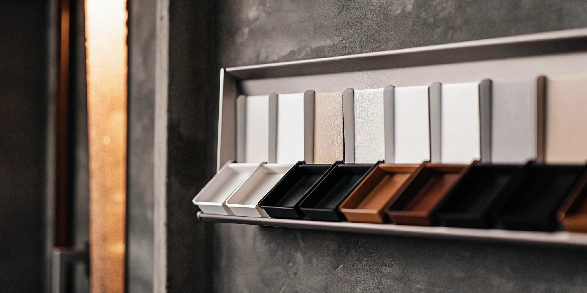 Several colorful magnetic marker trays holding dry erase markers on a whiteboard.