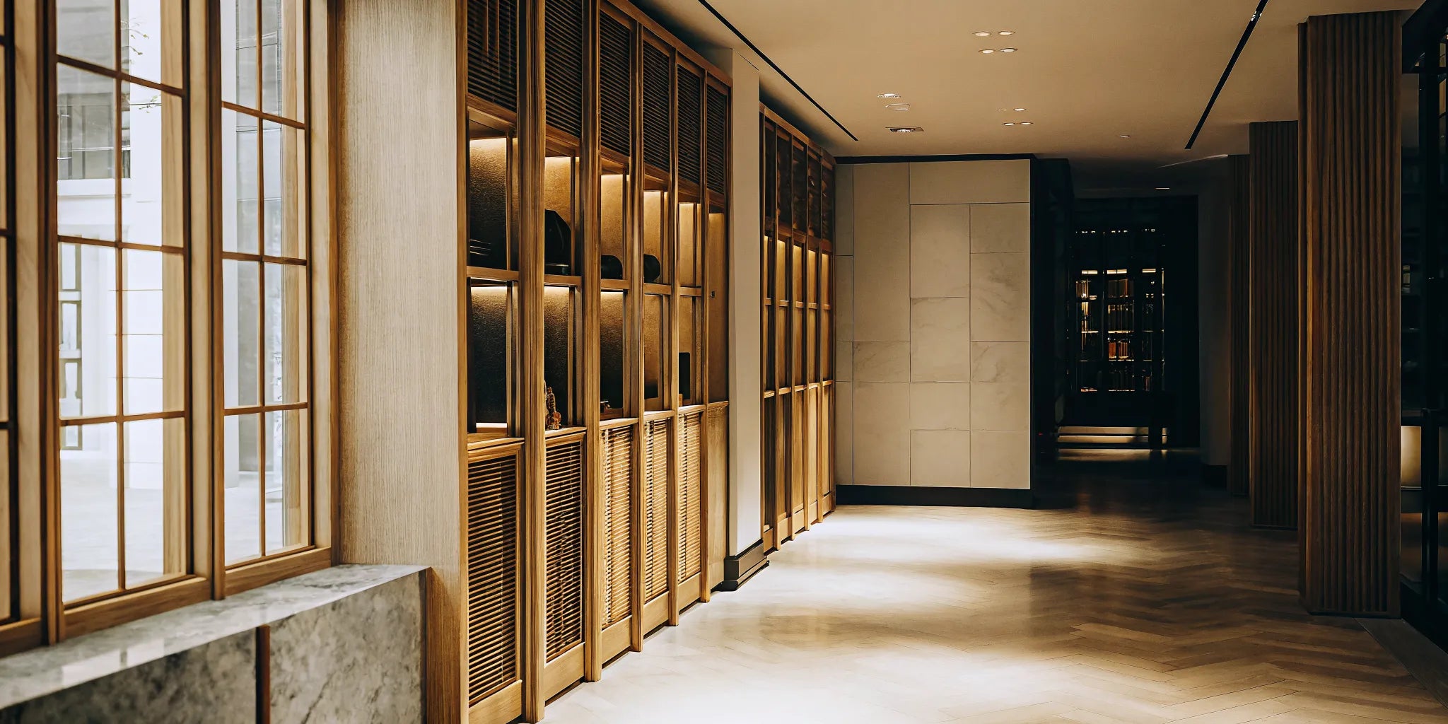 A collection of hats displayed on a modern wooden wall organizer in a hallway.
