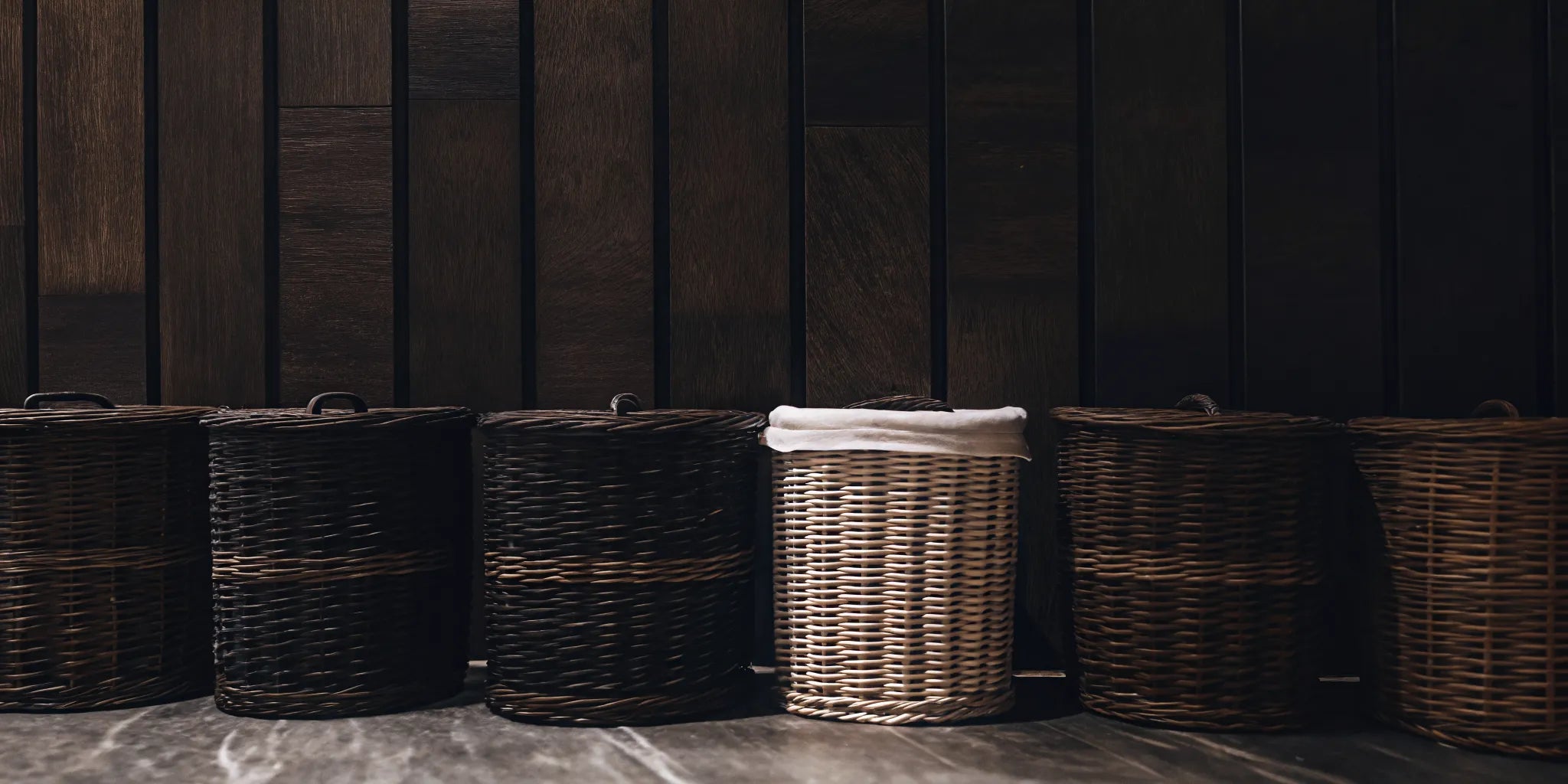 Several tall baskets with lids in various styles for home storage.