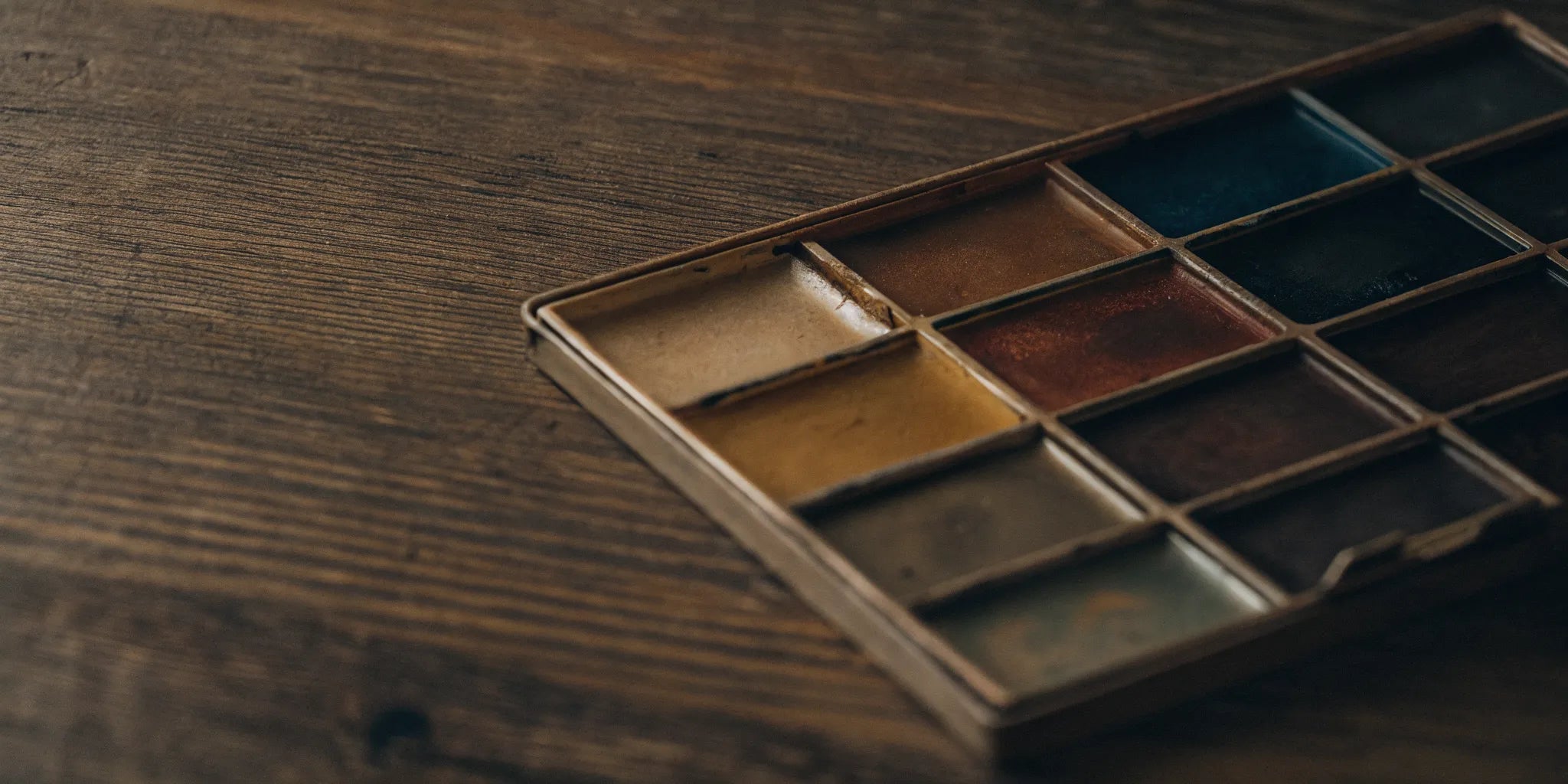 A compact mini travel watercolor set with a variety of color pans.