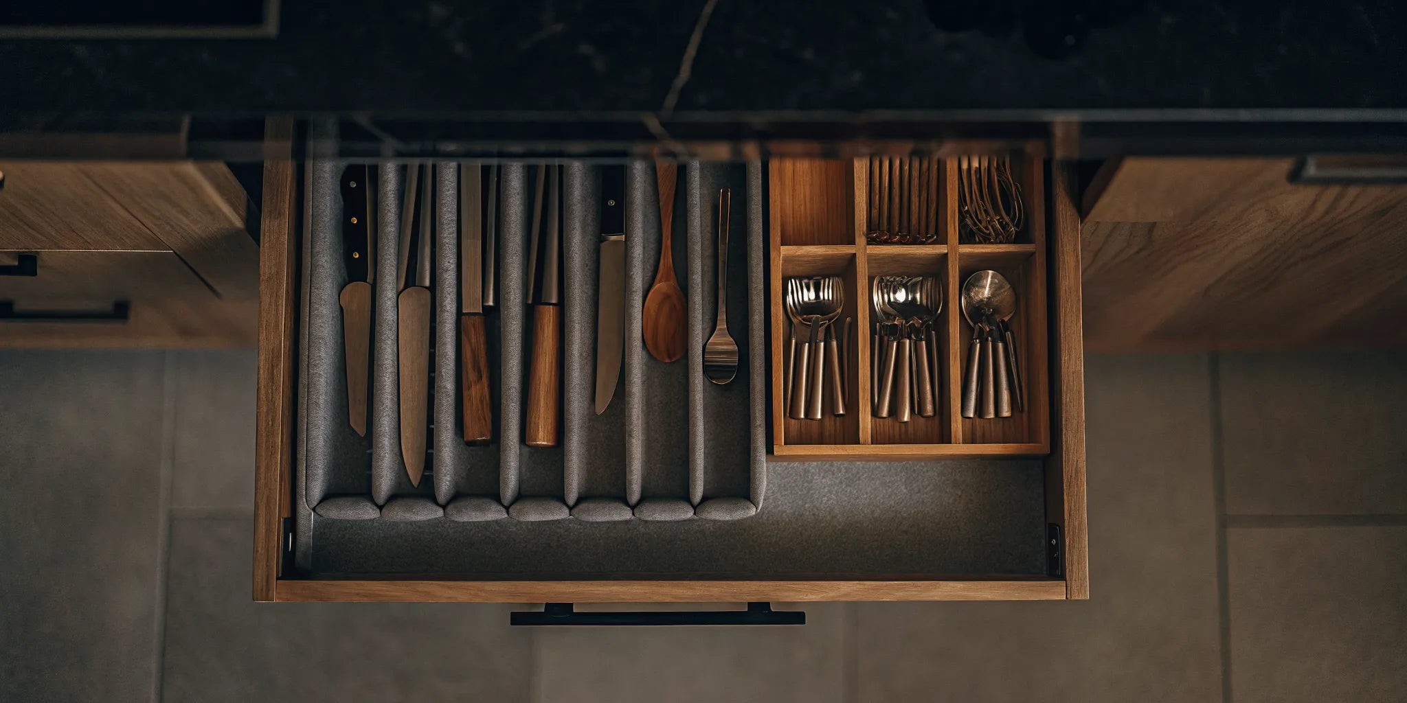 A set of felt kitchen drawer organizers neatly arranging silverware in a drawer.